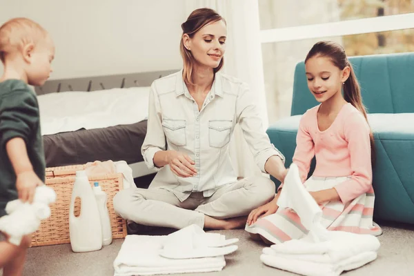Daughter Helps The Mother With Household Chores. Bright Room. Clean Laundry. Young Helper. Holiday Leisure. Family Relationship Concept. Domestic Problems. White Towels. Parent\'s Duty.