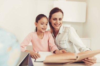 Anne kızı mutfakta ödev yapmak için yardımcı olur. Aile ilişki kavramı. Eğitim çocukluk. Evde eğitim. Bilgi alma. Bilgi yazma. Ebeveynler görev. Birlikte çalışma.