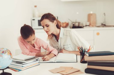 Anne kızı mutfakta ödev yapmak için yardımcı olur. Aile ilişki kavramı. Eğitim çocukluk. Evde eğitim. Bilgi alma. Bilgi yazma. Ebeveynler görev. Birlikte çalışma.