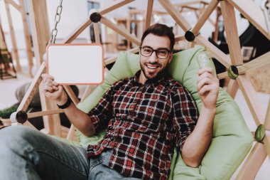 Beyaz tahta. Ampul. Fikirler oluşturur. İlham. Yaratıcı işçi. Sandalyeye asılı. Otur. Beyin fırtınası. Genç bir adam. İş adamı. Ofiste çalışıyor. İş adamları. Çalışma alanı. Gevşeme. Rahat.