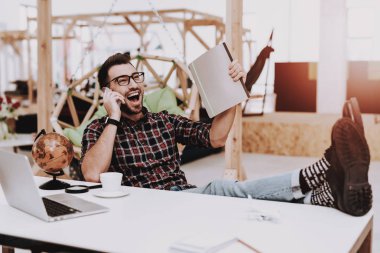 Klasör. Oh telefonda. Ayakları üzerinde tablo. Rahat. Küre. Proje. Dizüstü bilgisayar. Otur. Beyin fırtınası. Genç bir adam. İş adamı. İş. Office. Yaratıcı işçi. Fikirler. İş adamları. Çalışma alanı. İlham.
