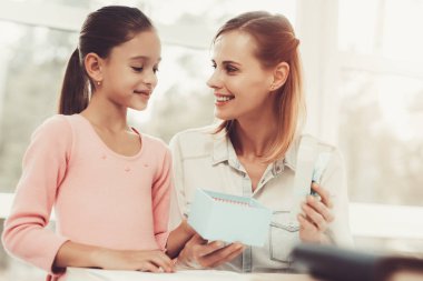 Anne ile kızı. Kavramı veren mevcut. Sorunları çözme. Resmi kıyafetler. Şükran bakışları. Kutuyu açın. Güzel anı. Üst görev. Aile ilişkisi var. Birlikte gülümseyen.