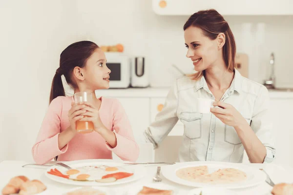 娘を持つお母さんが台所で夕食します 家族関係の概念 朝食時に楽しんでいます 朝の栄養 ジュースを飲んでいます 幸せな子供時代のコンセプトです ランチ時間 — ストック写真