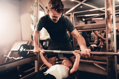 Baba Destek halter kaldırma sırasında oğula. Ebeveynlik ilişki. Sportif aile kavramı. Aktif yaşam tarzı. Dayanıklılık egzersiz. Holiday Leisure. Birlikte çalışma dışarı. Fitness gün.