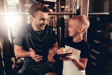 Baba ve oğul içinde jimnastik salonu. Tablet hakkında bilgi. Ebeveynlik ilişki. Sportif aile kavramı. Aktif yaşam tarzı. Mutlu çocukluk. Holiday Leisure. Birlikte çalışma dışarı. Fitness gün.