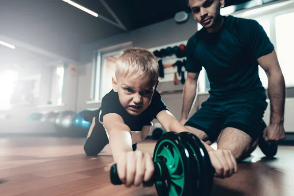 Sporty Child Is Doing Exercises With The Gym Wheel. Parenthood Relationship. Sporty Family Concept. Active Lifestyle. Press Exercise. Holiday Leisure. Working Out Together. Fitness Day.
