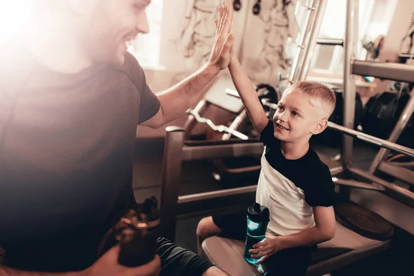 Father And Son Have A Break In Gym. High Five. Parenthood Relationship. Sporty Family Concept. Active Lifestyle. Having A Break. Holiday Leisure. Relaxing Together. Fitness Day. Time To Rest.