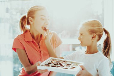 Kızı bir anne için bir kutu çikolata veriyor. Aile ilişki kavramı. Aktif tatil. Güzel anı. Üst sunmak. Mutlu çocukluk. Birlikte kutluyor. Lezzetli tatlılar.