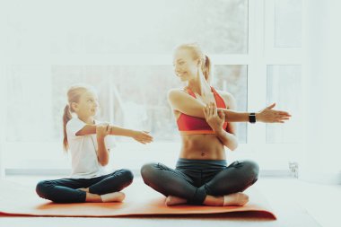 Anne ve kızı Yoga eğitim. Lotus pozisyonu. Aktif yaşam tarzı. Birlikte rahatlatıcı. Evde Fitness yapıyor. Holiday Leisure. Vücut dengesi. Spor egzersiz. Güneşli bir gün. Kollarını çapraz poz.