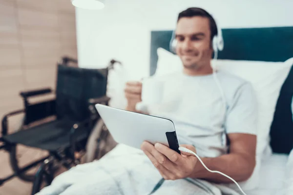 Mann Sieht Video Pad Kopfhörer Und Halten Tasse Das Verschwommene — Stockfoto