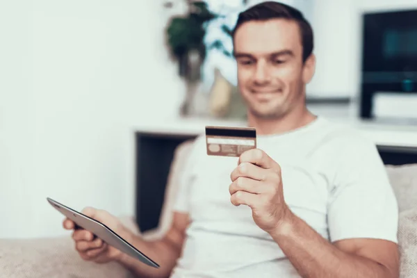 Blurred Person Holds Credit Card Uses Tablet Handsome Smiling Man — Stock Photo, Image