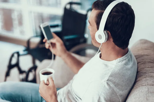 Mann Hört Musik Über Kopfhörer Und Hält Becher Der Hand — Stockfoto