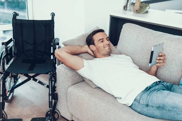 Homem Relaxante Sofá Com Tablet Perto Cadeira Rodas Bonito Feliz — Fotografia de Stock