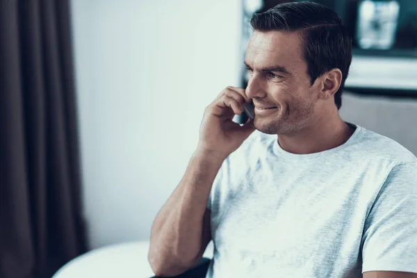 英俊的微笑的人说话的电话肖像 特写镜头关闭快乐白种人棕色头发的男人在室内穿着白色 男性沟通使用智能手机显示友好的表达 — 图库照片