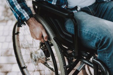 Yakın çekim. Engelli adam tekerlekli sandalye Park tarih. Engelli genç adam rahatlatıcı yaz Park. Eğlenceli yaz Park. Kurtarma ve sağlık kavramları. Kareli gömlekli adam. Oturan adam.