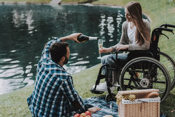 Tekerlekli sandalye ile piknik Park adam kız. Engelli genç kadın. Tekerlekli sandalye kadınlarda. Yaz Park'ta rahatlatıcı. Yaz Park piknik. Kurtarma ve sağlık kavramları. Neşeli insanlar.