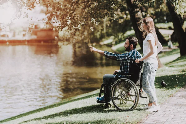 几个残疾人在公园附近的轮椅在湖 残疾青年男子妻子和丈夫 在夏季公园的日期 浪漫的关系 恢复和医疗保健概念 快乐夫妇 — 图库照片