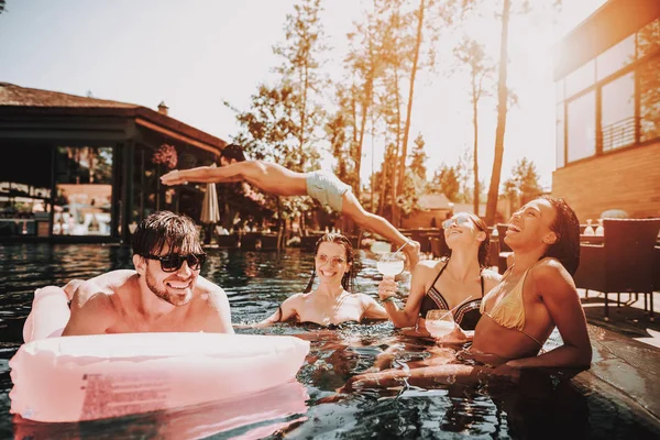 一群在泳池里游泳的快乐青年 年轻的微笑的朋友们穿着太阳镜笑和放松在户外酒店泳池旁边的池边 暑假的概念 泳池派对 — 图库照片