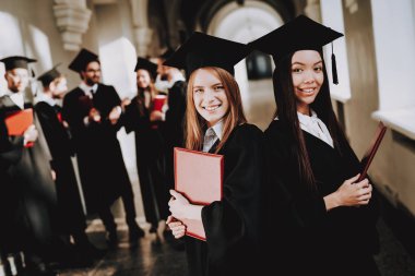 Diploma. Ayakta. Koridor. Kızlar. Mimarisi. Mutluluk. İstihbarat. Üniversitesi. Elbiseler. Mezunu. Mutlu. İyi bir ruh hali. Üniversitesi. Neşeli. Kutlama. Kap. Kampüs. Adam bilgi. Harç kurulu.