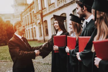 Öğretmen. Öğrencilerin diploma. Avlu. Üniversitesi. Çalışmaları bitirmek. Mezunu. Çocuklar. Selamlıyorum. Bir grup genç insan. İyi bir ruh hali. İyi eğlenceler. Dostluk. Bilgi. Kap. Neşeli. Kutlama.