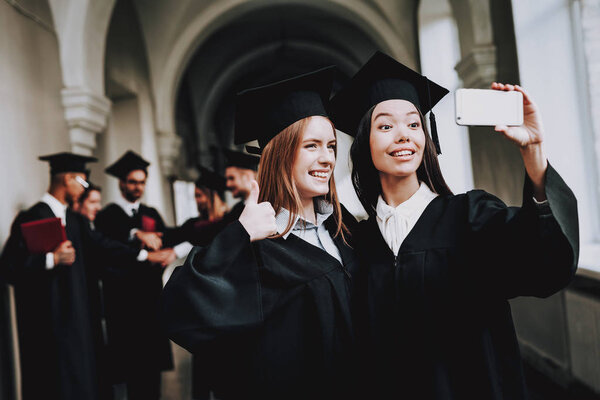 Happiness. Girls. Intelligence. Diploma. University. Graduate. Happy. Good Mood. University. Cheerful. Celebration. Cap. Campus.Black Mantles. Selfie. Architecture. Man. Knowledge. Mortar Board.