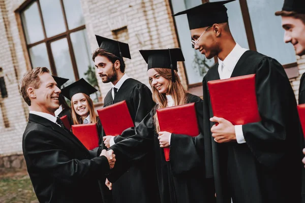 Çalışmaları bitirmek. Öğretmen. Öğrencilerin diploma. Avlu. Üniversitesi. Mezunu. Çocuklar. Selamlıyorum. Bir grup genç insan. İyi bir ruh hali. İyi eğlenceler. Dostluk. Bilgi. Kap. Neşeli. Kutlama.