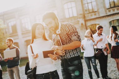 Kitaplar. İstihbarat. Erkek ve kadın. Birlikte ayakta. Dışarıda. Güneşli bir gün. Öğrenciler. Arkadaşlar elinde. Mutlu. Öğrenciler. Avlu. Kitaplar. Üniversitede ayakta. İyi bir ruh hali. Üniversitesi. Bilgi.