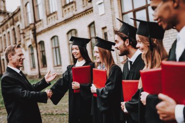 İyi bir ruh hali. Öğretmen. Öğrencilerin diploma. Avlu. Üniversitesi. Çalışmaları bitirmek. Mezunu. Çocuklar. Selamlıyorum. Bir grup genç insan. İyi eğlenceler. Dostluk. Bilgi. Kap. Neşeli. Kutlama.