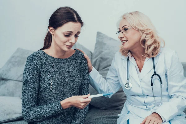 年轻的苗条的女人在灰色毛衣访问医生 穿白衣的女人饮食和保健概念 用听诊器做的多镜 灰色沙发上的女人 医疗设备 眼镜中的妇女 — 图库照片