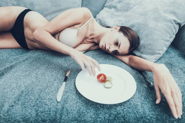 Slim Girl Con Anoressia Sdraiato Sul Divano Con Piastra Verdure — Foto Stock