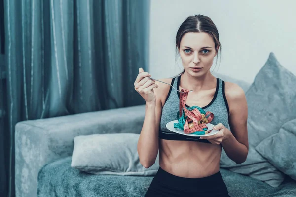 Young Woman with Tailors centimeter on Plate. Girl with Tailors Centimeter. Diet and Healthcare Concepts. Woman in White Room. Young Girl with Anorexia. Woman in Bra. Girl on Diet.
