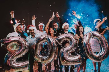 Yeni yıl kutlama Baloons gülümseyen insanlarla. Yeni yıl kutlama. Elbiseli Genç kadın. Takım elbiseli Genç adam. Santa Claus Cap. Gri Baloons insanlarla. Yeni Yılınız Kutlu Olsun. İnsanlar iyi eğlenceler.