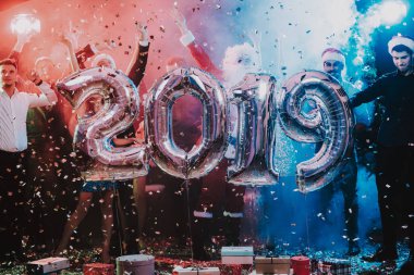 Yeni yıl kutlama Baloons gülümseyen insanlarla. Yeni yıl kutlama. Elbiseli Genç kadın. Santa Claus elbiseli Genç adam. Gri Baloons insanlarla. Yeni Yılınız Kutlu Olsun. İnsanlar iyi eğlenceler.