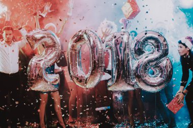 Yeni yıl kutlama Baloons gülümseyen insanlarla. Yeni yıl kutlama. Elbiseli Genç kadın. Santa Claus elbiseli Genç adam. Gri Baloons insanlarla. Yeni Yılınız Kutlu Olsun. İnsanlar iyi eğlenceler.