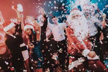 Adam Santa Claus kılık yeni yıl partisi. Yeni Yılınız Kutlu Olsun. İnsanlar iyi eğlenceler. Kapalı parti. Yeni yıl kutlama. Elbise genç kadınlar. Elbiseli Genç adamlar. Mutlu insanlar. Beyaz sakallı.
