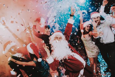 Adam Santa Claus kılık yeni yıl partisi. Yeni Yılınız Kutlu Olsun. İnsanlar iyi eğlenceler. Kapalı parti. Yeni yıl kutlama. Elbise genç kadınlar. Elbiseli Genç adamlar. Mutlu insanlar. Beyaz sakallı.