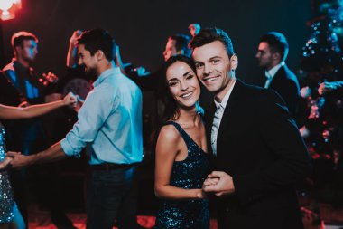 Yeni yıl partisi üzerinde dans mutlu gençler. Yeni Yılınız Kutlu Olsun. İnsanlar iyi eğlenceler. Kapalı parti. Yeni yıl kutlama. Elbiseli Genç kadın. Takım elbiseli Genç adam. Mutlu insanlar. Modern dansları.