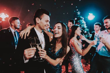 Yeni yıl partisi üzerinde dans mutlu gençler. Mutlu yeni yıl kavramı. Bir bardak şampanya. Yeni yıl kutlama. Elbiseli Genç kadın. Takım elbiseli Genç adam. Mutlu insanlar. Modern dansları.