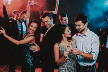 Yeni yıl partisi üzerinde dans mutlu gençler. Mutlu yeni yıl kavramı. Bir bardak şampanya. Yeni yıl kutlama. Elbiseli Genç kadın. Takım elbiseli Genç adam. Mutlu insanlar. Modern dansları.