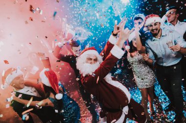 Adam Santa Claus kılık yeni yıl partisi. Yeni Yılınız Kutlu Olsun. İnsanlar iyi eğlenceler. Kapalı parti. Yeni yıl kutlama. Elbise genç kadınlar. Elbiseli Genç adamlar. Mutlu insanlar. Beyaz sakallı.