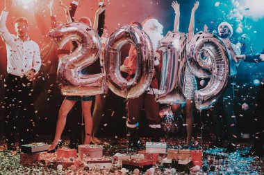 Yeni yıl kutlama Baloons gülümseyen insanlarla. Yeni yıl kutlama. Elbiseli Genç kadın. Santa Claus elbiseli Genç adam. Gri Baloons insanlarla. Yeni Yılınız Kutlu Olsun. İnsanlar iyi eğlenceler.