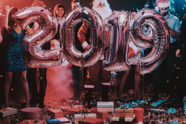 Yeni yıl kutlama Baloons gülümseyen insanlarla. Yeni yıl kutlama. Elbiseli Genç kadın. Santa Claus elbiseli Genç adam. Gri Baloons insanlarla. Yeni Yılınız Kutlu Olsun. İnsanlar iyi eğlenceler.