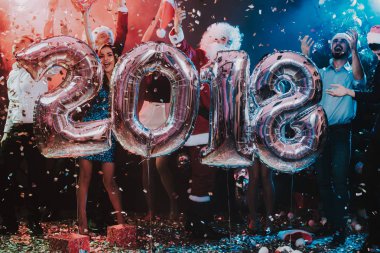 Yeni yıl kutlama Baloons gülümseyen insanlarla. Yeni yıl kutlama. Elbiseli Genç kadın. Santa Claus elbiseli Genç adam. Gri Baloons insanlarla. Yeni Yılınız Kutlu Olsun. İnsanlar iyi eğlenceler.