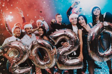 Yeni yıl kutlama Baloons gülümseyen insanlarla. Yeni yıl kutlama. Elbiseli Genç kadın. Takım elbiseli Genç adam. Santa Claus Cap. Gri Baloons insanlarla. Yeni Yılınız Kutlu Olsun. İnsanlar iyi eğlenceler.