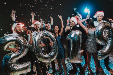 Yeni yıl kutlama Baloons gülümseyen insanlarla. Yeni yıl kutlama. Elbiseli Genç kadın. Takım elbiseli Genç adam. Santa Claus Cap. Gri Baloons insanlarla. Yeni Yılınız Kutlu Olsun. İnsanlar iyi eğlenceler.