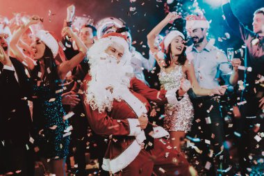 Adam Santa Claus kılık yeni yıl partisi. Yeni Yılınız Kutlu Olsun. İnsanlar iyi eğlenceler. Kapalı parti. Yeni yıl kutlama. Elbise genç kadınlar. Elbiseli Genç adamlar. Mutlu insanlar. Beyaz sakallı.