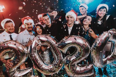 Yeni yıl kutlama Baloons gülümseyen insanlarla. Yeni yıl kutlama. Elbiseli Genç kadın. Takım elbiseli Genç adam. Santa Claus Cap. Gri Baloons insanlarla. Yeni Yılınız Kutlu Olsun. İnsanlar iyi eğlenceler.