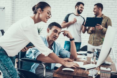 Genç işçiler Modern ofiste sohbet edelim. İş yerinde beyin fırtınası. Gülümseyen kadın. Adam tekerlekli sandalye üzerinde. Gülümseyen Yöneticisi. Office çalışmasında. Genç bir işçi. Meslektaşları ile oturan adam iletişim.