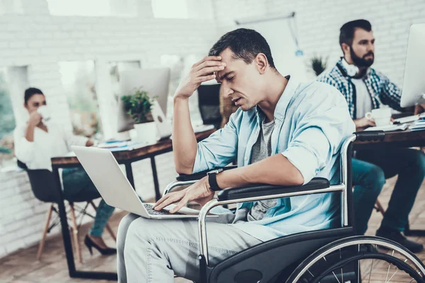 Ofiste Tekerlekli Sandalyede Gözlüklü Yorgun Adam. Laptop ile Çalışan. Engelli Genç Adam. Tekerlekli Sandalyedeki Adam. Kurtarma ve Sağlık Kavramları. Ofiste takım çalışması. Genç İşçi. Oturan Adam.