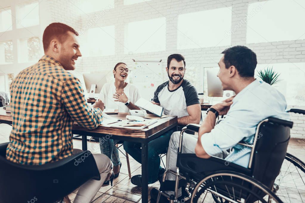 Young Workers Have Discussion in Modern Office. Brainstorm at Work. Smiling Woman. Man on Wheelchair. Smiling Manager. Teamwork in Office. Plan Presentation. Communication with Colleagues.